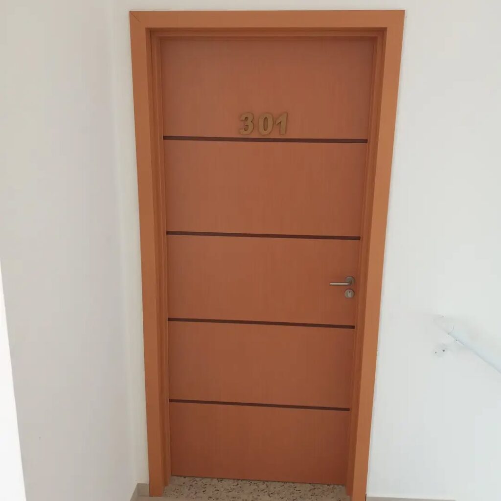 Instalação de porta de madeira com design moderno e número personalizado.