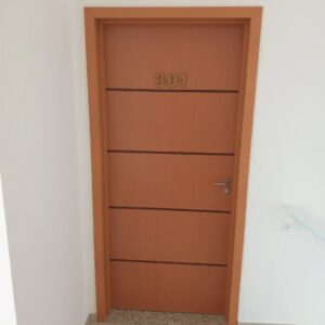 Instalação de porta de madeira com design moderno e número personalizado.