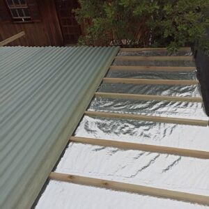 Manutenção de telhados com isolamento térmico e estrutura de madeira reforçada.