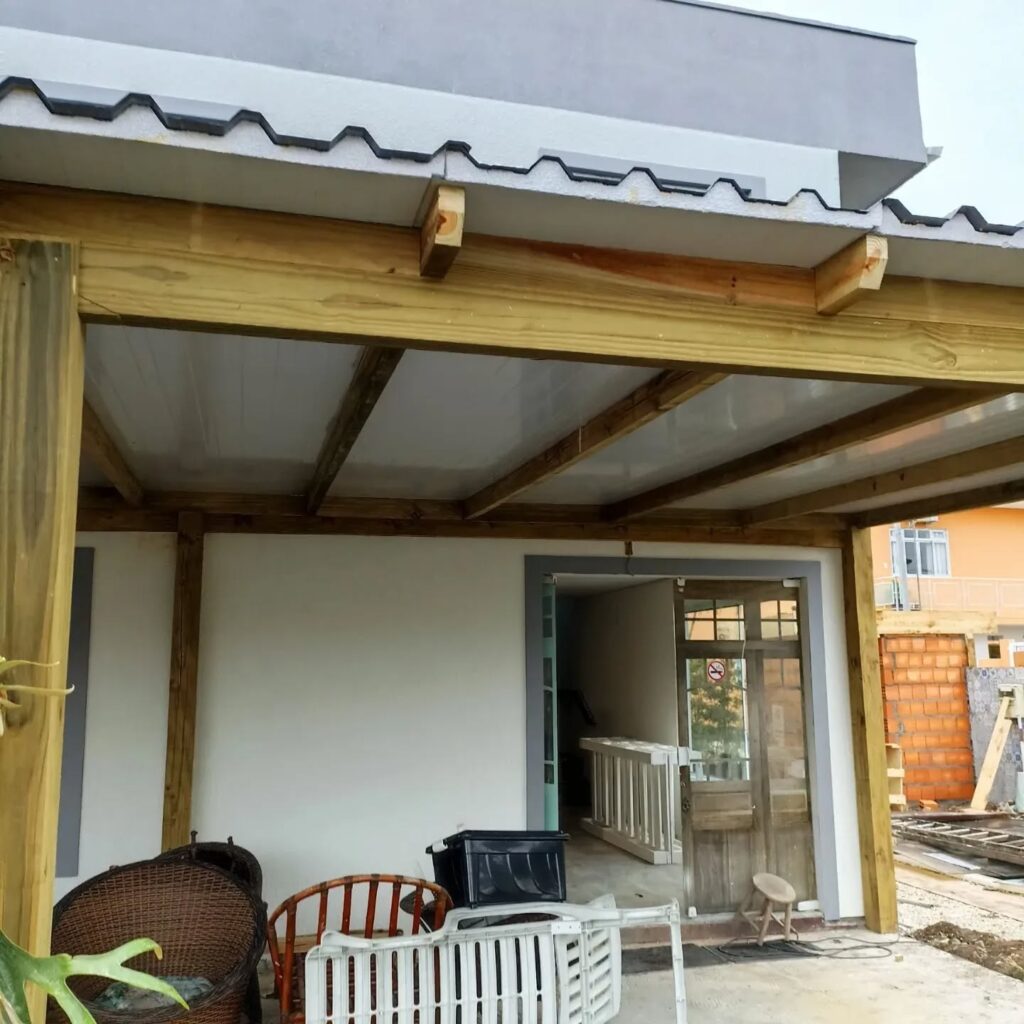 Reforma residencial com estrutura de madeira e cobertura de telhas e policarbonato.