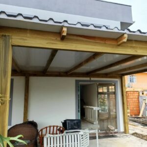 Reforma residencial com estrutura de madeira e cobertura de telhas e policarbonato.